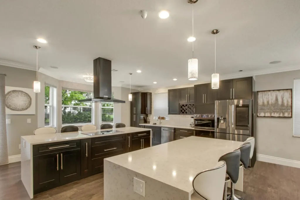 Kitchen with dark wood cabinetry, light countertops and island seating