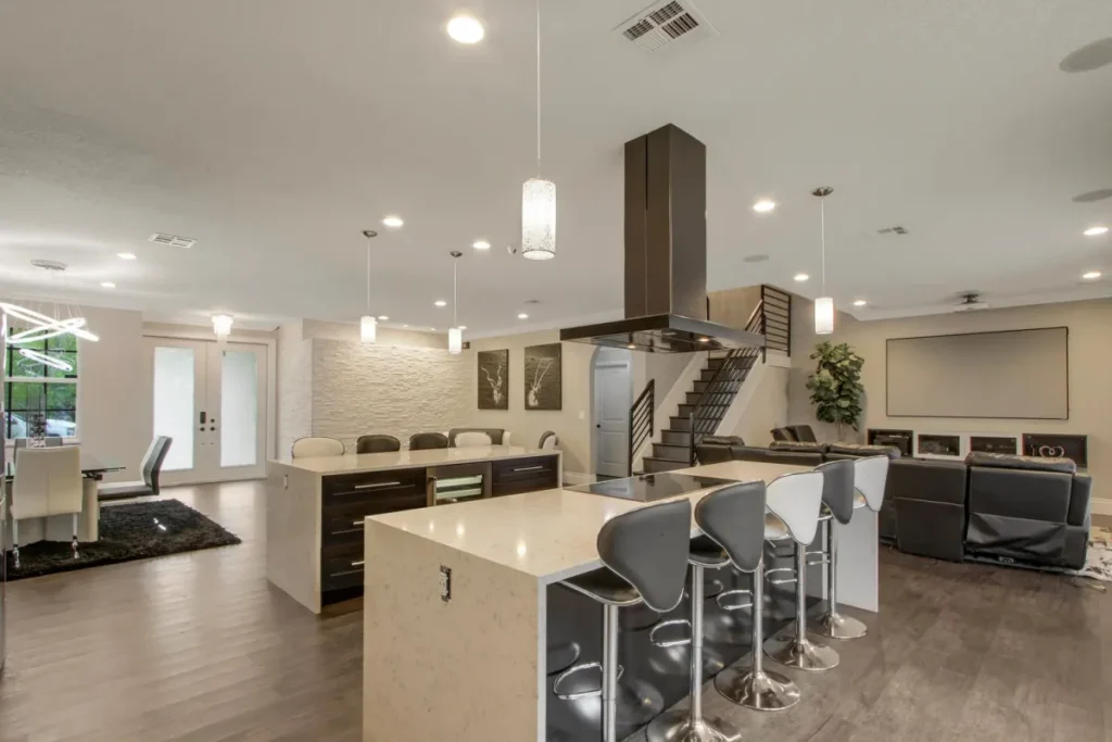 Open-plan kitchen with two islands, dark cabinetry and pendant lighting